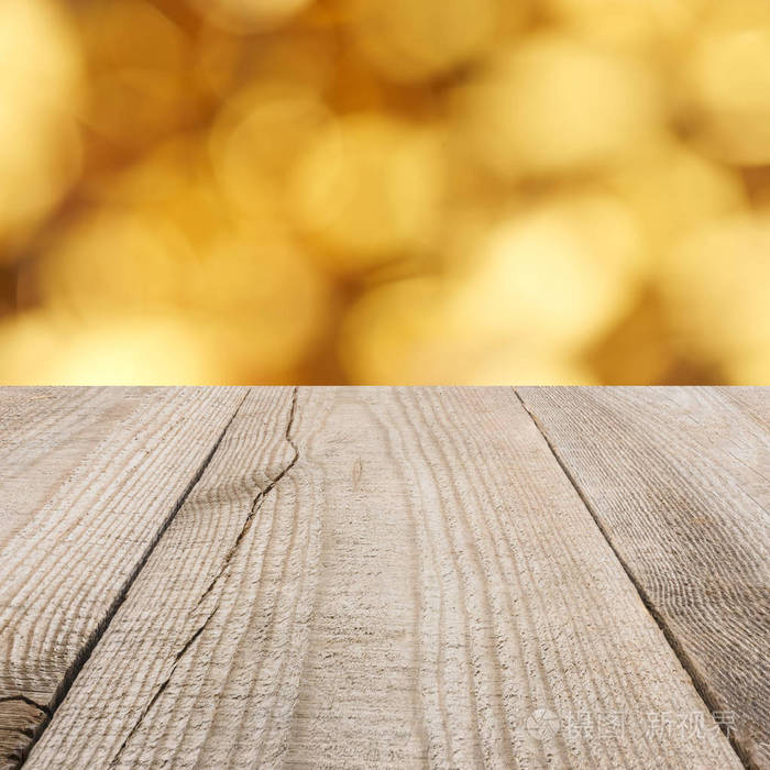 浅褐色木板表面有模糊的金色背景
