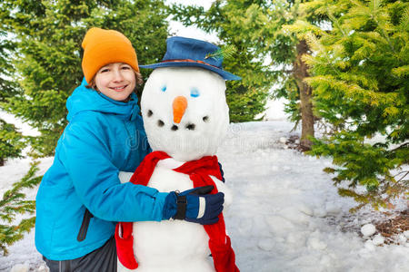 男孩在冬天用红领巾堆雪人