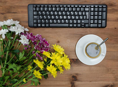电脑键盘，杯咖啡和花屋桌