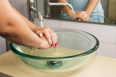用肥皂在自来水下洗手