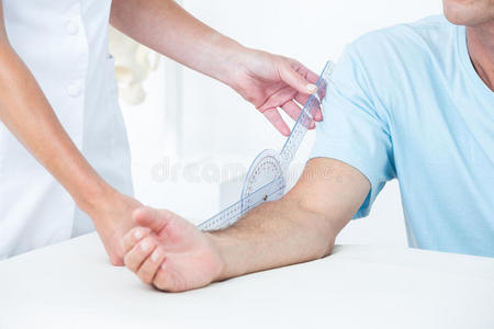 医生用测角仪测量手臂照片