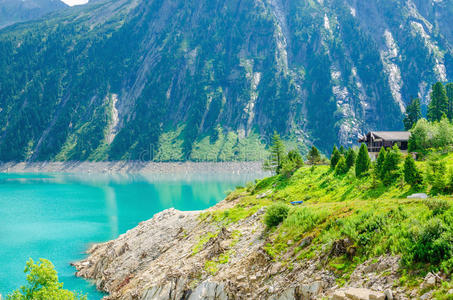 奥地利阿尔卑斯山的蔚蓝湖畔木屋和山峰