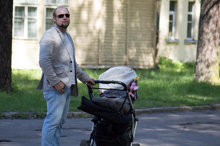 父亲带着婴儿马车走路