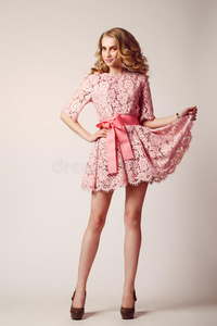 美容工作室肖像的女孩穿粉红色连衣裙，波浪发型