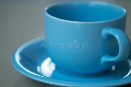 灰色背景上的蓝色咖啡杯