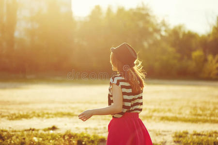 穿着帽子和衣服在公园散步的女孩。