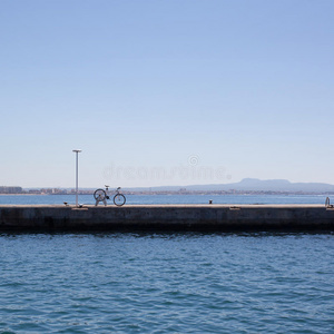 骑自行车在码头上对抗大海和蓝天