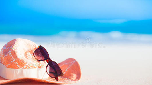 热带海滩上的太阳镜和草帽