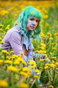 美丽的嬉皮士替代年轻女子绿色头发坐在草地上与蒲公英在公园