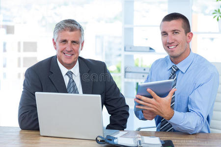 商人与笔记本电脑和平板电脑一起工作