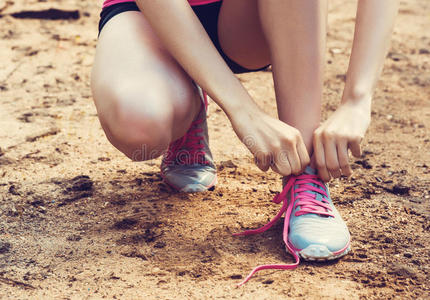 女人系鞋带的特写。 女性运动健身运动员准备在森林小径I上户外慢跑