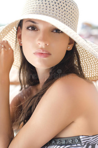 海滩上戴帽子的漂亮女孩。