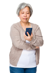 亚洲老妇人在智能手机上看书