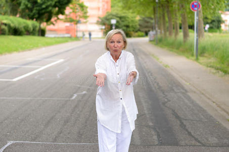 成年妇女穿着全白色的衣服在街上散步