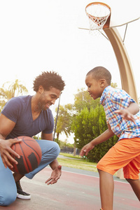 父亲和儿子一起在公园打篮球