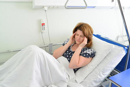 医院病房床上头痛的女性患者