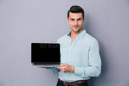 英俊的男人显示空白的笔记本电脑屏幕