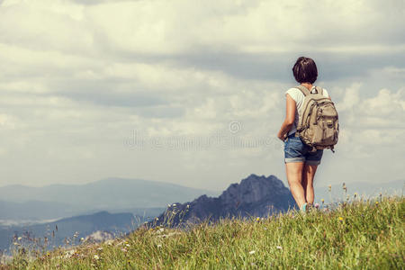 一个女人在长满草的山上，背背