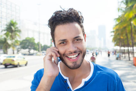 英俊的巴西男人在城市打电话