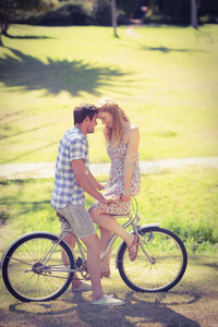 可爱的一对夫妇在公园骑自行车