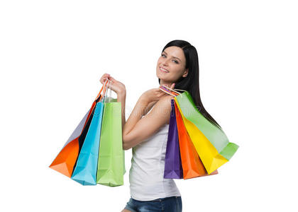 一个快乐的黑发女人，从高档商店里拿着五颜六色的购物袋。