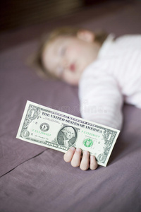 婴儿睡觉时手里拿着美元