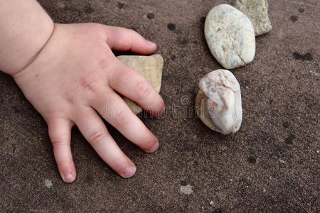 孩子的手碰着一块石头