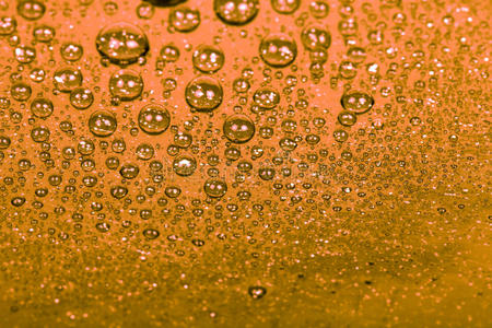 彩色背景上的水滴。 橙色。 浅深度的f