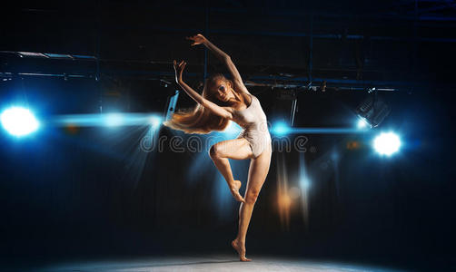 迷人的年轻金发芭蕾舞演员在舞台上摆姿势