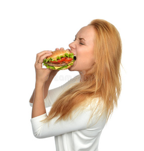 快餐概念。女人吃美味不健康的汉堡三明治