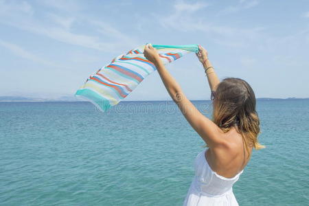 女孩在海边挥动一条五颜六色的围巾