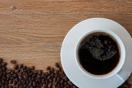 木质背景上的一杯黑咖啡和咖啡豆。