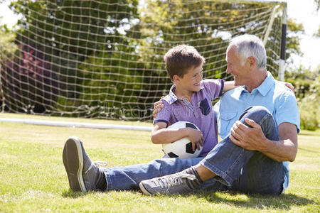 祖父和孙子在花园里踢足球