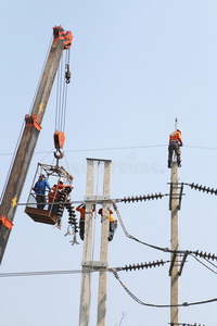 电工通过连接高压电线在高处工作。