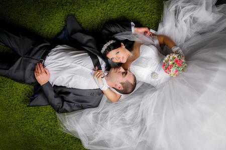 新娘和新郎躺在草一样的地毯上