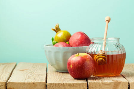 蓝色背景的木桌上的苹果和蜂蜜