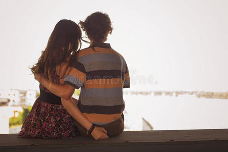 夏日的阳光下，一对年轻夫妇在城外的一座桥上拥抱。复制空间