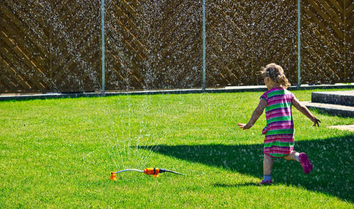 女孩玩花园喷头