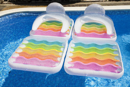 夏季游泳池里五颜六色的漂浮空气床垫