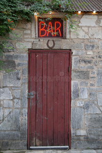 红色门上方的酒吧标志