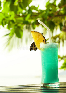 蓝色夏威夷鸡尾酒与菠萝在黑暗的桌子上