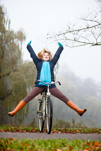 女孩在秋天的公园里骑自行车放松