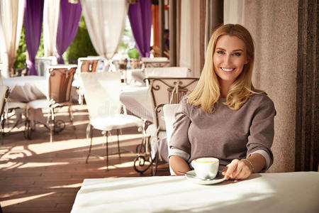 漂亮的金发商务女人餐厅喝咖啡茶