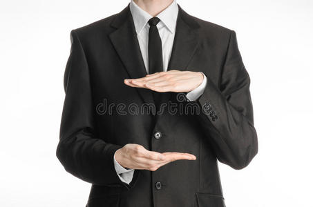 商人和手势主题一个穿着黑色西装和领带的人在他面前握着两只手，并在白色隔离物上显示大小