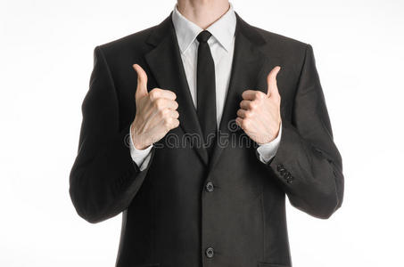 商人和手势主题一个穿着黑色西装，戴着领带的男人，双手竖起大拇指，孤立在演播室的白色背景上