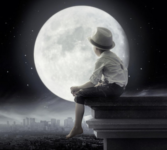 一个小男孩坐在屋顶上的黑白照片照片