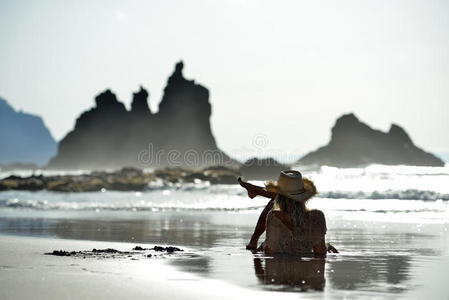 夏天坐在海滩上的年轻女子