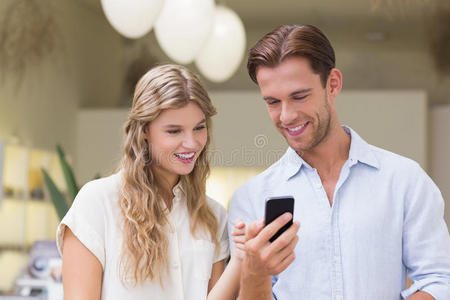 一对幸福的夫妇看着智能手机