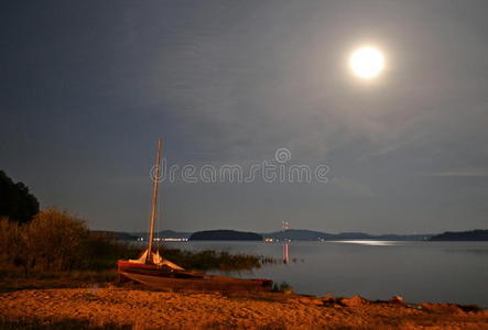 夜晚在月光下在湖岸上的船