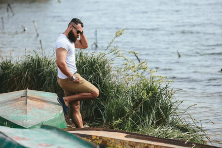 美国胡子男子在河边用电话